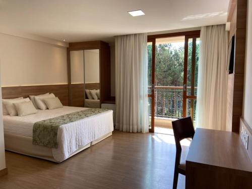 a hotel room with a bed and a balcony at Apartamento em Pedra Azul, Condomínio Vista Azul in Pedra Azul