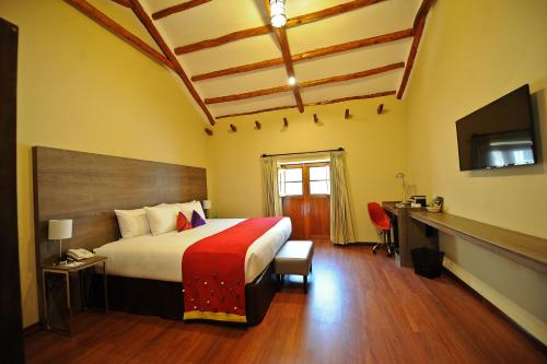 a hotel room with a bed and a television at Union Hotel Cusco in Cusco