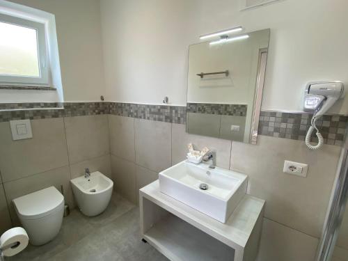 a bathroom with a sink and a toilet and a mirror at InVilla Bed&Breakfast - Quality Rooms in Santa Maria di Castellabate