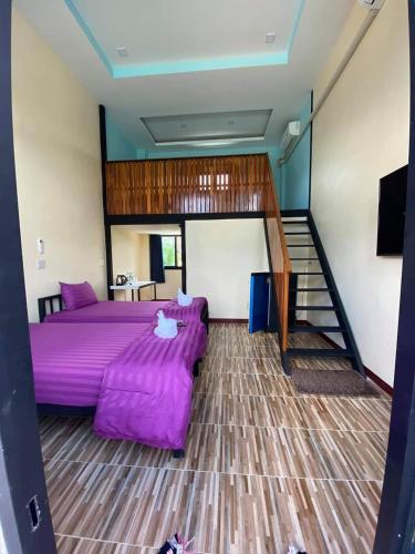 a bedroom with a purple bed and a staircase at BN Resort in Ban Nong Chum Saeng
