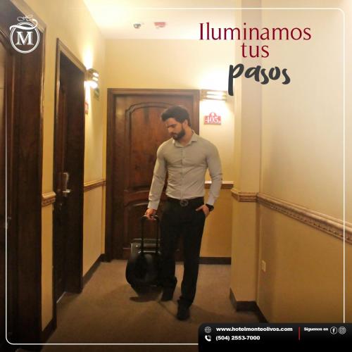 a man walking down a hallway holding a bag at Hotel Monteolivos in San Pedro Sula