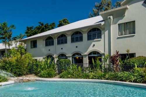 una casa con piscina delante de una casa en Privately Managed Apartments in Mango Resort Palm Cove, en Palm Cove
