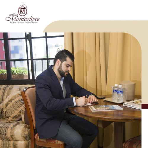 a man in a suit sitting at a table at Hotel Monteolivos in San Pedro Sula