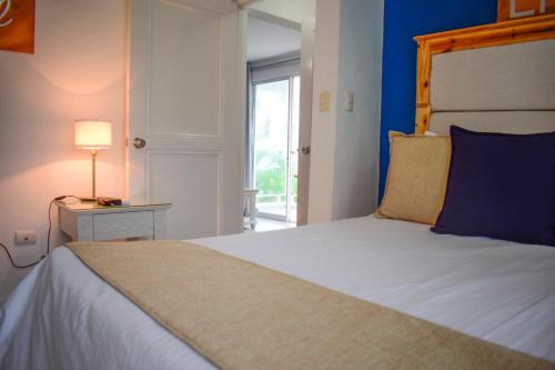 a bedroom with a large bed with a blue wall at Hotel Checkin El Cortecito Beach in Punta Cana