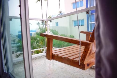 a porch swing on the balcony of a building at Hotel Checkin El Cortecito Beach in Punta Cana