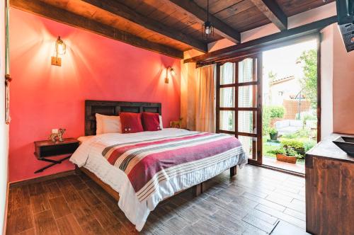 a bedroom with a bed with a red wall at Yox Hotel Boutique in San Cristóbal de Las Casas