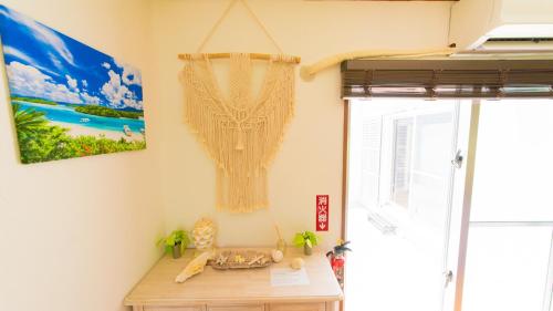 Zimmer mit einem Holztisch und einem Fenster in der Unterkunft Palm Villa Ishigakijima fusu in Ishigaki-jima