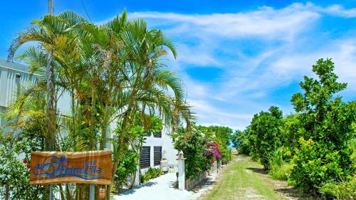 a palm tree next to a white building at Palm Villa Ishigakijima fusu in Ishigaki Island