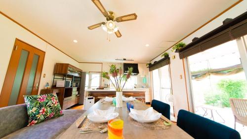 a living room with a table and a ceiling fan at Palm Villa Ishigakijima fusu in Ishigaki Island