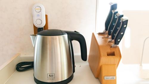 a tea kettle on a counter next to a guitar at Palm Villa Ishigakijima fusu in Ishigaki Island