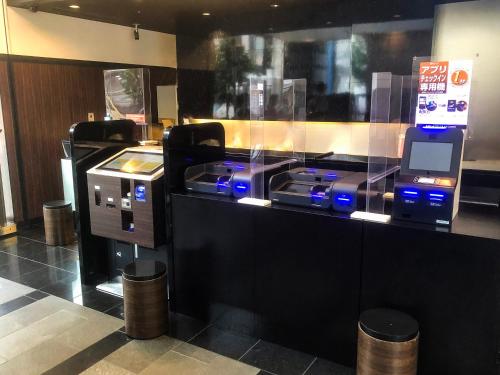 a ticket counter with a ticket machine in a store at APA Hotel Naha Matsuyama in Naha