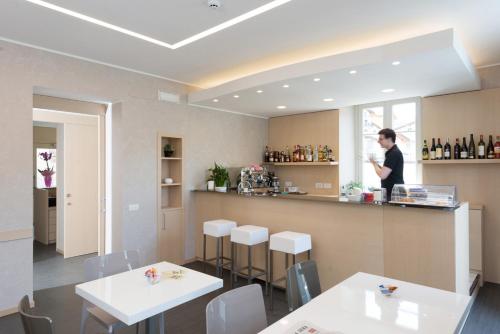 a person standing at a counter in a restaurant at Hotel Helvetia in Lezzeno