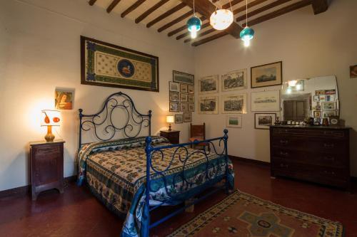 a bedroom with a bed and a dresser and pictures on the wall at Appartamento del Capitano in Cortona