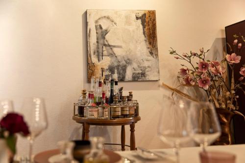 a table with wine bottles on a table with flowers at Hotel de Charme Römerhof in Arbon