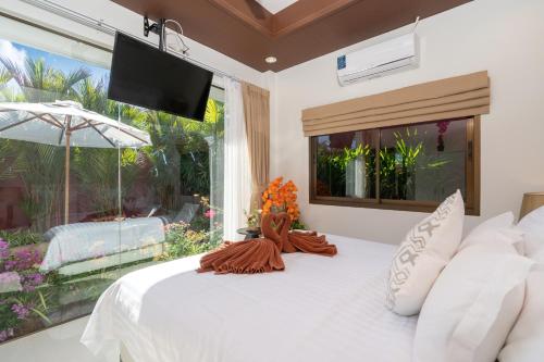 a bedroom with a white bed and a large window at Boutique Resort Private Pool Villa - SHA Extra Plus in Ban Pa Khlok
