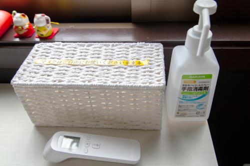 a bottle of laundry detergent next to a basket and a bottle of milk at 北谷日漁別荘 in Chatan