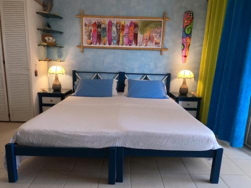 a bedroom with a large bed with blue walls at Green Garden Apartment in Christ Church