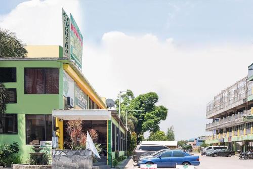 un coche azul estacionado frente a un edificio en OYO 195 Ranchotel - Biñan, en Biñan