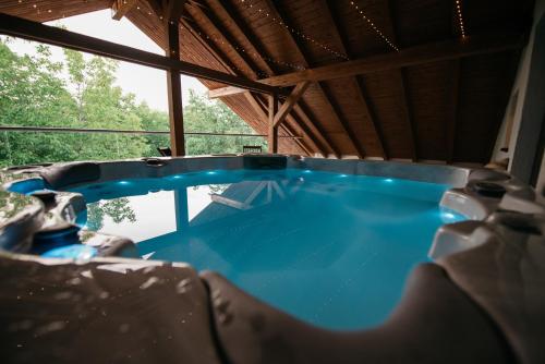 a hot tub in a house with a window at Nuez Apartments in Dumbrăviţa