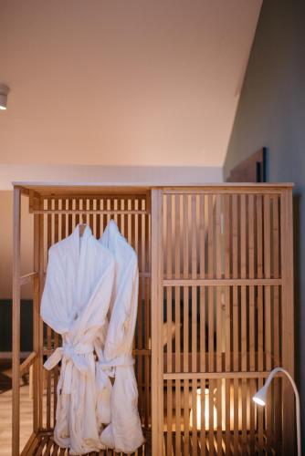 a wooden cage with a white robe on it at Nuez Residence in Dumbrăviţa