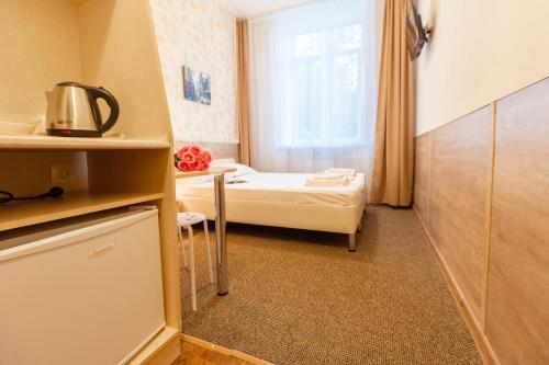 um pequeno quarto com uma cama e uma janela em Hotel Kolos em Tyumen