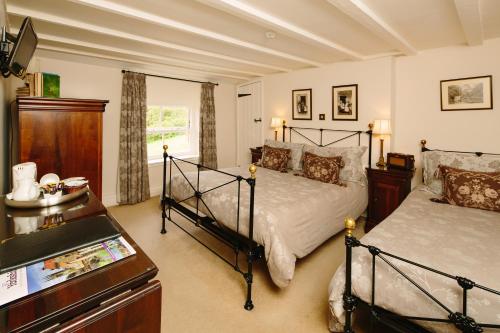 a bedroom with two beds and a dresser in it at Duke Of Wellington Inn in Danby