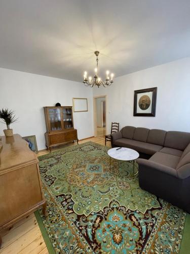 een woonkamer met een bank en een tafel bij Apartament w starej kamienicy w Reszlu in Reszel