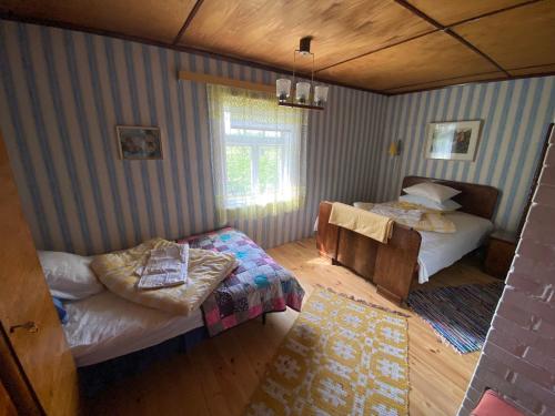 Vintage Countryhouse في Valgesoo: غرفة نوم بسريرين وكرسي فيها