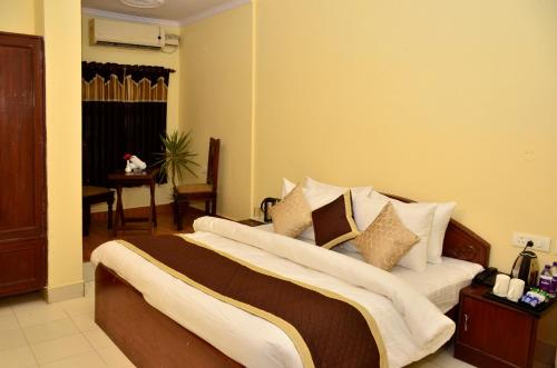 a bedroom with a large bed with white sheets and pillows at Mahal Rajwada-A Heritage Resort in Jaipur