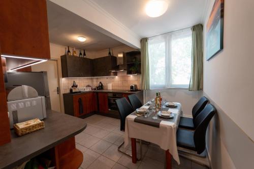 een kleine keuken met een tafel en stoelen in een keuken bij VIP Apartman Balatonföldvár in Balatonföldvár