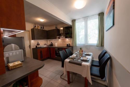 małą kuchnię ze stołem i krzesłami w kuchni w obiekcie VIP Apartman Balatonföldvár w Balatonföldvárze