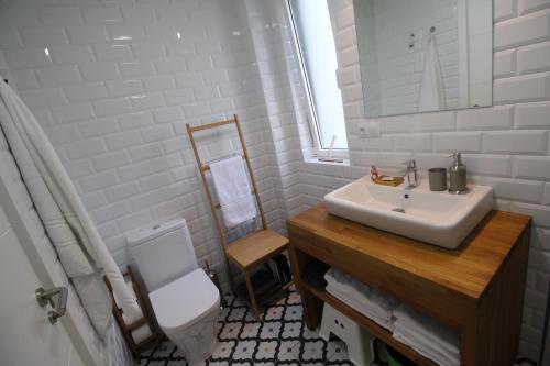 a white bathroom with a sink and a toilet at Apartamento 2 dormitorios con piscina y jardín - Apartamentos Montesomo in Somo