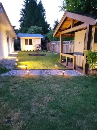a backyard with lights in the grass at JoyVeal’s Homey Place in Sechelt