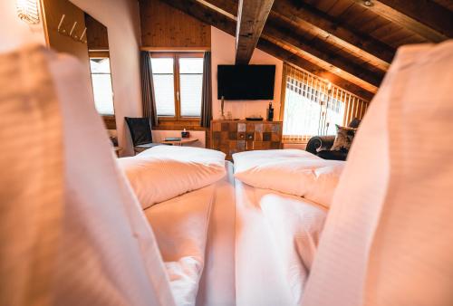 ein Zimmer mit einem Haufen Betten darin in der Unterkunft DESIGn und FERIEN HOTEL CHRISTANIA in Fiesch