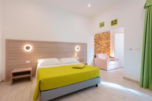 a bedroom with a yellow bed and a couch at Bardilio Luxury Rooms in Cagliari