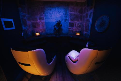 two chairs in a dark room with a man in the background at CHRIStania in Fiesch