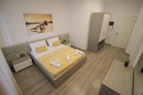 a hotel room with a bed, desk and a television at Zero Zero Apartments Sarande in Sarandë