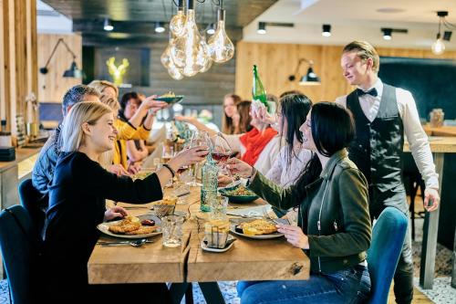 a group of people sitting around a table with wine glasses at Hotel & Restaurant Herzstück Waldkirchen in Waldkirchen