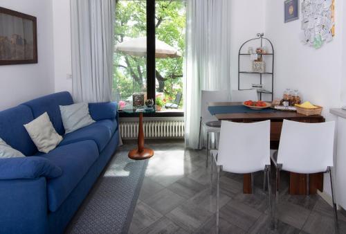 a living room with a blue couch and white chairs at Casali appartamento in San Marino