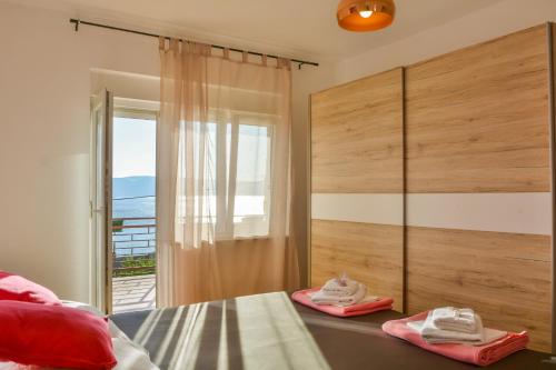 une chambre avec un lit et une porte coulissante en verre dans l'établissement Apartmani Krijesnica, à Senj