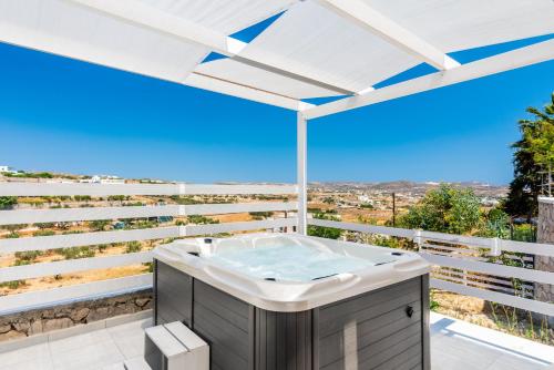 a hot tub on the balcony of a house at Alexandros Village in Adamas