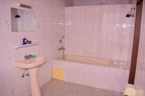 a bathroom with a sink and a bath tub at ROMO house in Cotonou