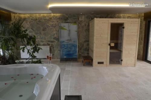 a large bathroom with a bath tub in a room at Adorable appartement avec piscine in Durtal