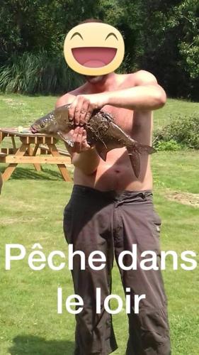 a man holding two fish with a frisbee at Appartement à la campagne avec piscine in Durtal