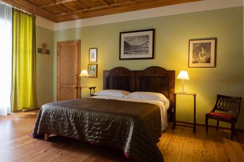 um quarto com uma cama grande e uma cadeira em Tenuta Perusini em Corno di Rosazzo