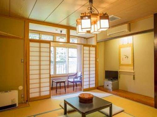 a living room with a table and a dining room at Oyado Fubuki in Nozawa Onsen