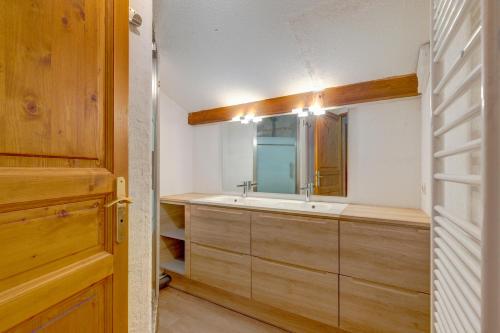 uma casa de banho com um lavatório e um espelho em L'Ecureuil em Flumet