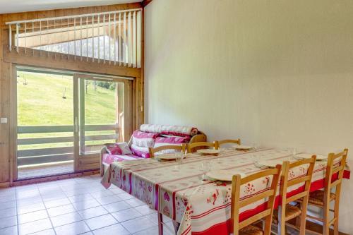 une salle à manger avec une table et des chaises et une fenêtre dans l'établissement L'Ecureuil, à Flumet