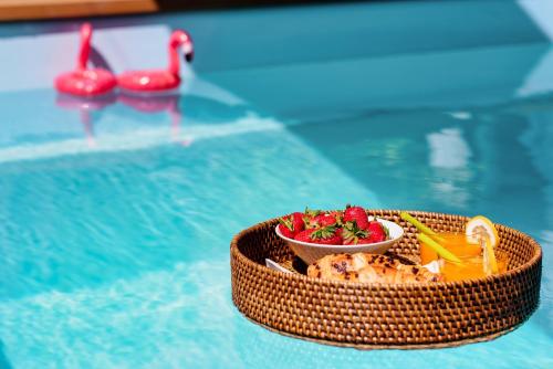 a table with a bowl of food in a swimming pool at Evala luxury rooms with pool and garden in Split
