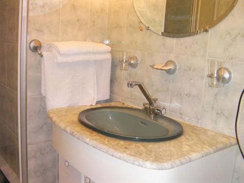 La salle de bains est pourvue d'un lavabo et d'un miroir. dans l'établissement Hôtel-Restaurant Le Rouffillac, à Carlux